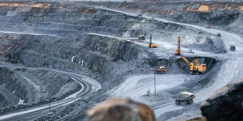 In an open pit gold mine, machines work to extract the metal.