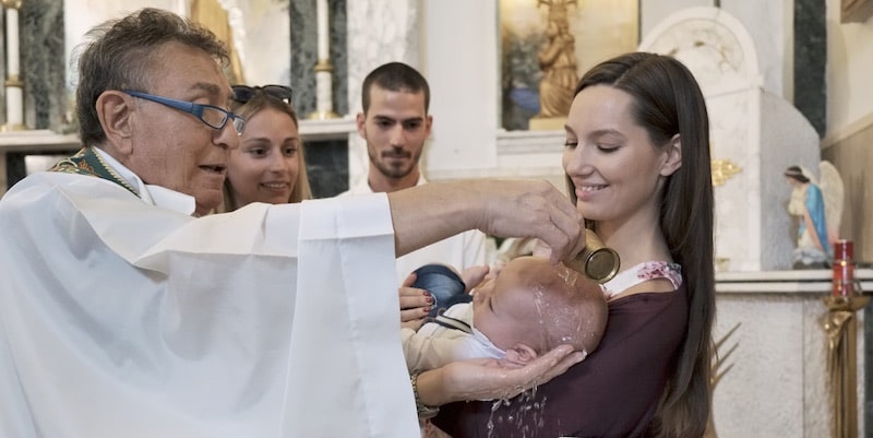 A priest performs the baptism rite.