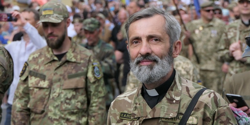 A military priest parades with his battalion companions.