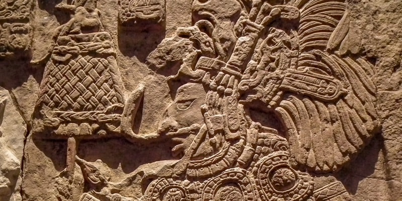 A stone relief carving shows stories from Aztec mythology.