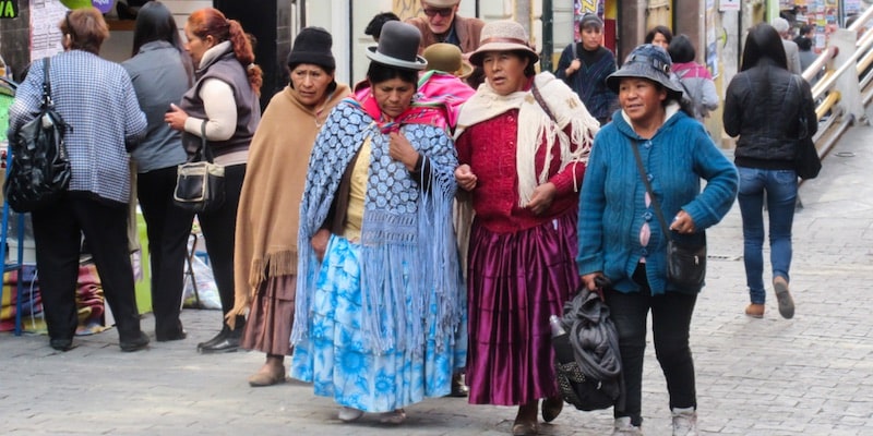 Women of different ethnicities and traditions walk through the city of La Paz, Bolivia.