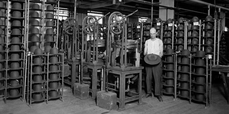 A worker shows the production of hats in a factory.