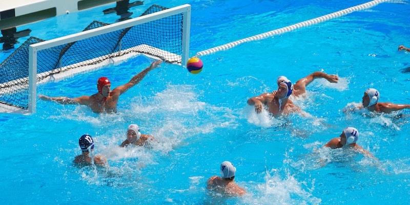 Two water polo teams face off in a pool.