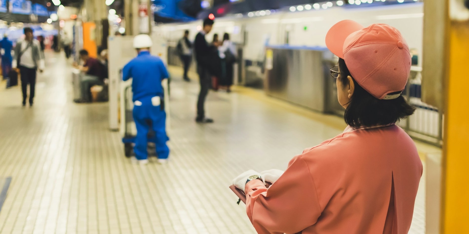 A researcher observes workers and passengers at a train station.