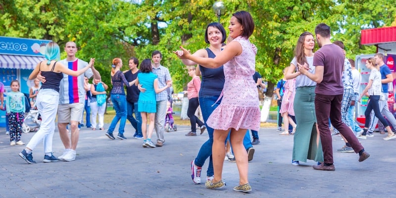 A group of people dance in the park.