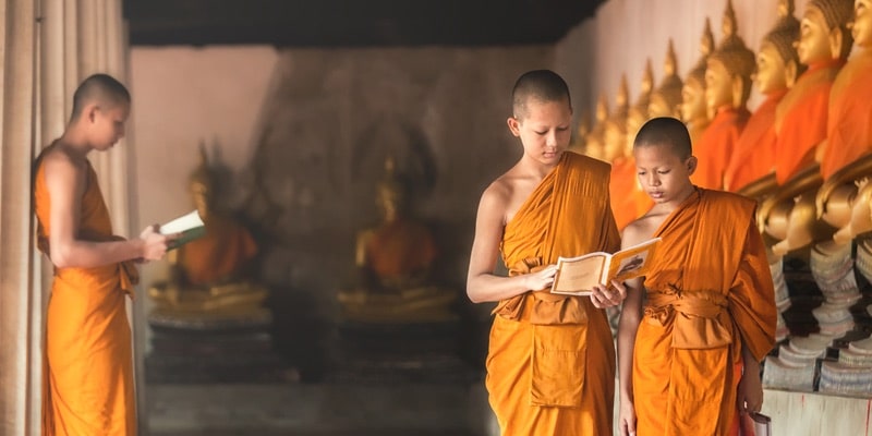 Two Buddhist apprentices study in a temple.