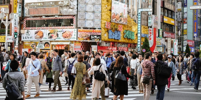 People walk through the streets of Tokyo.